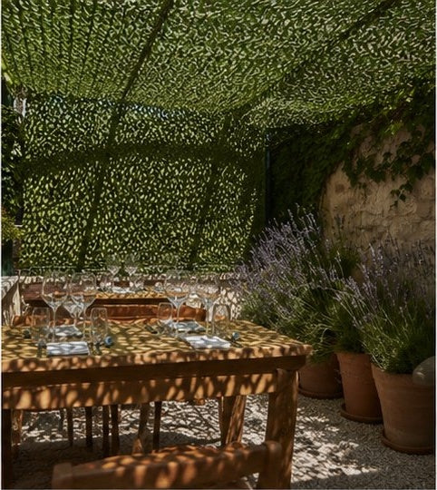 Filet d'ombrage vert au-dessus d'une table de jardin près de lavandes