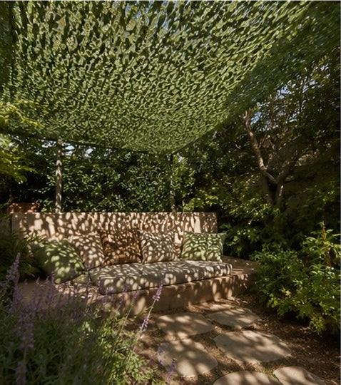 Filet d'ombrage vert ombrageant un banc de jardin
