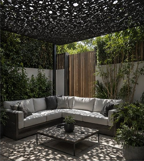 Filet d'ombrage noir tendu sur un salon de jardin avec canapé