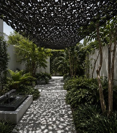Filet d'ombrage noir tendu entre les arbres d'un jardin